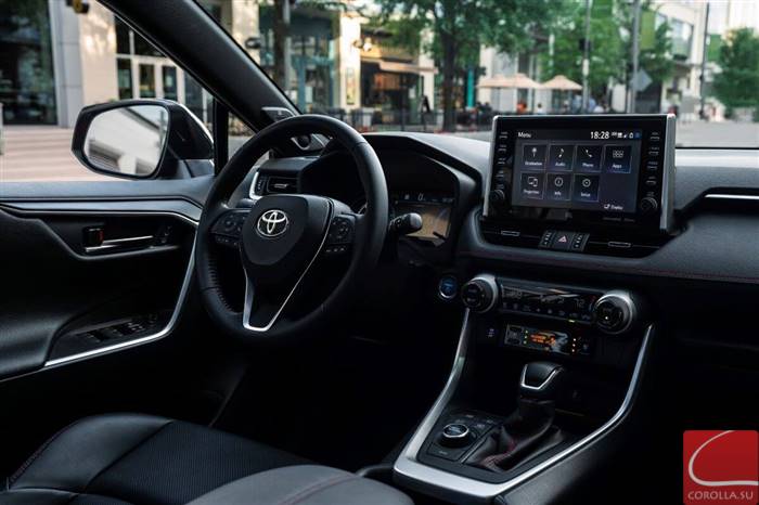 The driver's seat, driver's display, transmission, and infotainment touchscreen inside a 2023 Toyota RAV4 Prime